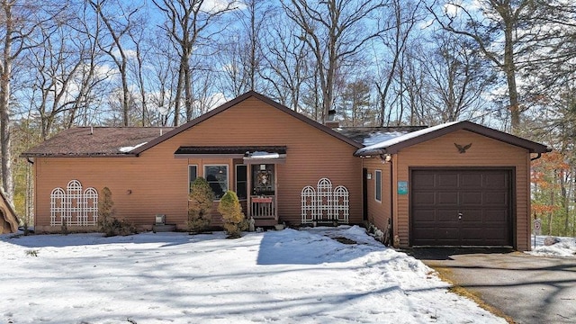 rustic home featuring aphalt driveway and an attached garage