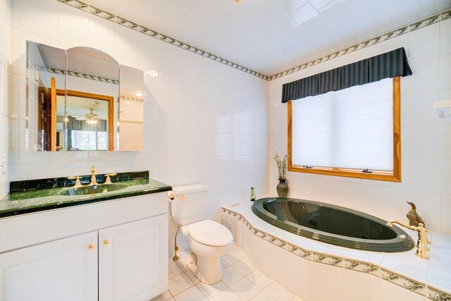 161 Barker Rd, Glen Spey, NY 12737 - bathroom with tile walls, a jetted tub, tile patterned floors, vanity, and toilet