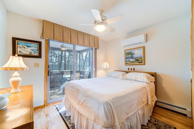 161 Barker Rd, Glen Spey, NY 12737 - bedroom with a wall mounted AC, a baseboard radiator, access to outside, and light wood-type flooring