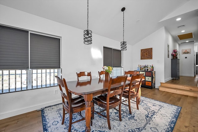 dining area with vaulted ceiling and wood-type flooring