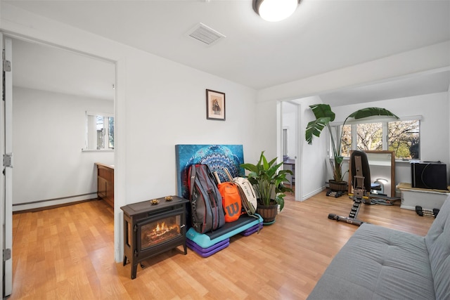 workout room featuring hardwood / wood-style flooring, a baseboard radiator, and plenty of natural light