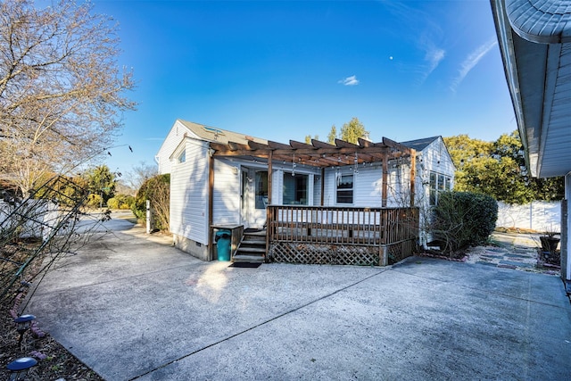 view of front of property featuring a wooden deck, a patio, and a pergola