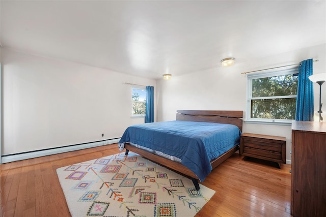 bedroom with light wood-type flooring and baseboard heating