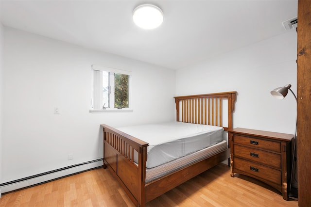 bedroom with a baseboard radiator and light hardwood / wood-style flooring