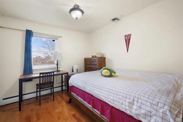 bedroom featuring a baseboard radiator and hardwood / wood-style floors