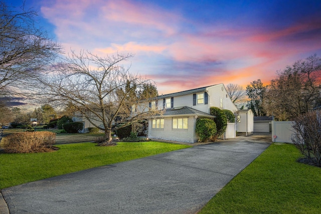 front of property with an outbuilding, a garage, and a lawn