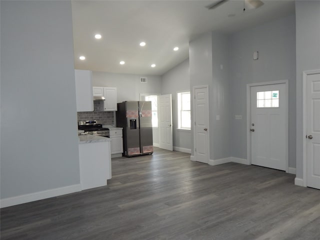 kitchen featuring tasteful backsplash, white cabinetry, appliances with stainless steel finishes, and dark hardwood / wood-style flooring