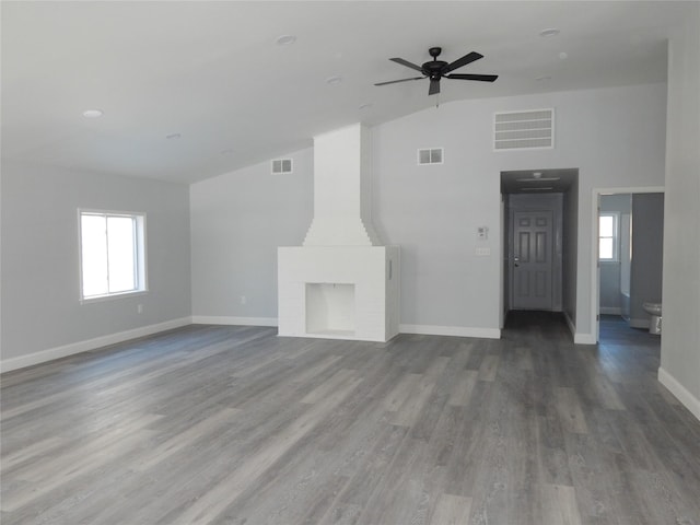 unfurnished living room with vaulted ceiling, ceiling fan, a fireplace, and hardwood / wood-style floors