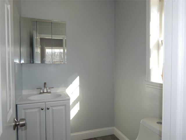 bathroom with vanity, plenty of natural light, and toilet