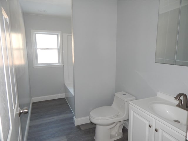 bathroom with hardwood / wood-style flooring, vanity, and toilet