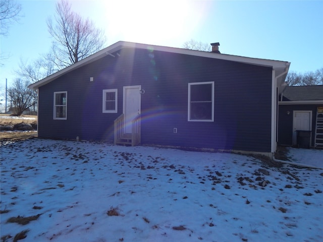 view of snow covered rear of property