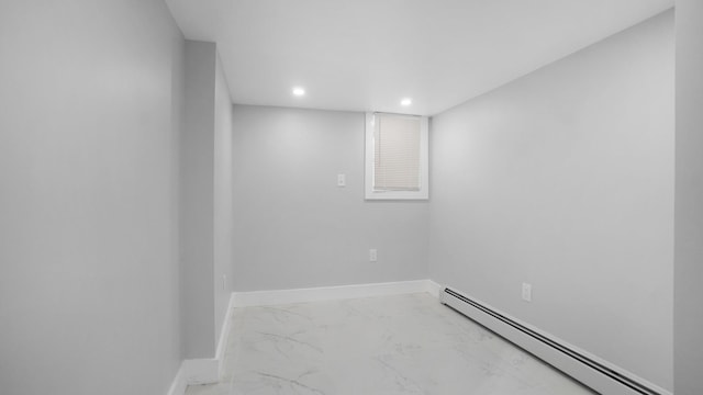 empty room with a baseboard heating unit, recessed lighting, marble finish floor, and baseboards