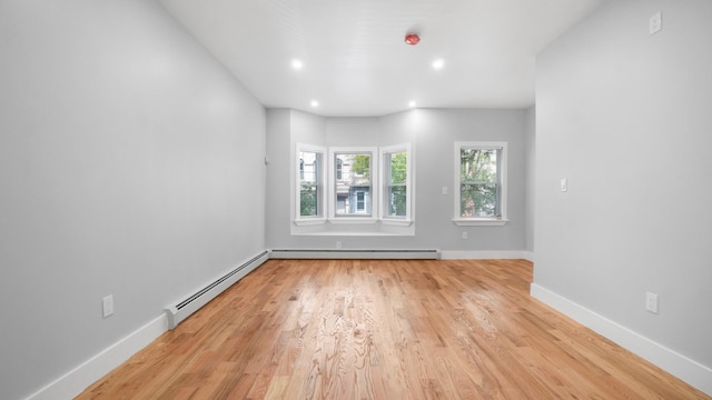 spare room with light wood finished floors, baseboards, baseboard heating, a baseboard heating unit, and recessed lighting