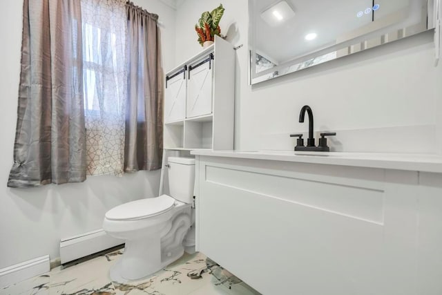 bathroom with toilet, sink, and a baseboard heating unit