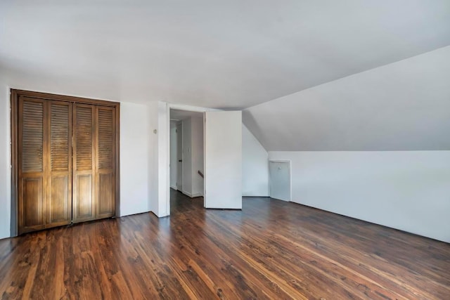 additional living space featuring lofted ceiling and dark wood-type flooring