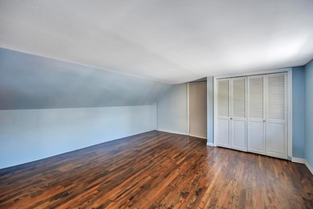 additional living space with dark hardwood / wood-style floors and vaulted ceiling