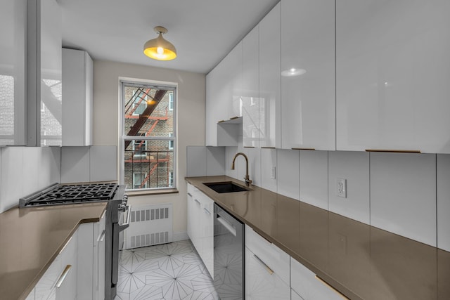 601 Kappock St Unit 3P, Bronx, NY 10463 - kitchen with radiator, tasteful backsplash, white cabinetry, sink, and stainless steel appliances