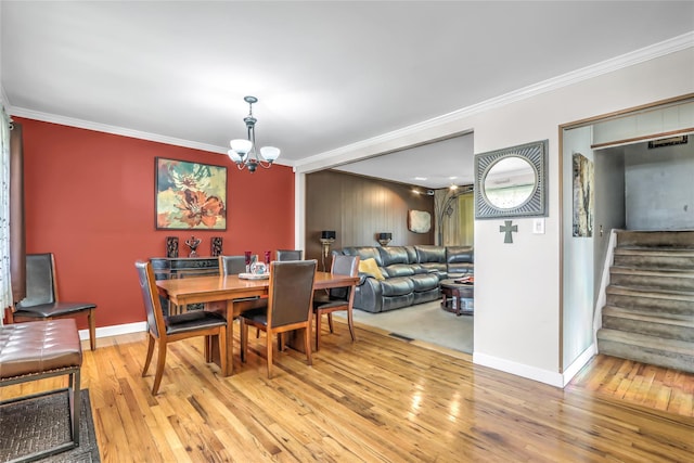 dining space featuring ornamental molding, a chandelier, and hardwood / wood-style floors