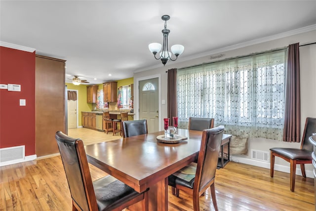 dining room featuring crown molding, ceiling fan with notable chandelier, and light hardwood / wood-style floors