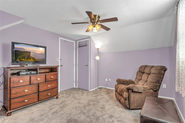 living area featuring ceiling fan, light colored carpet, and lofted ceiling