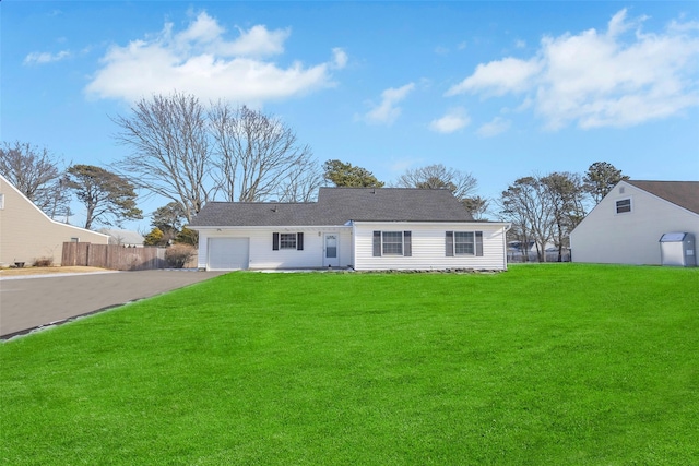 rear view of property featuring a garage and a yard