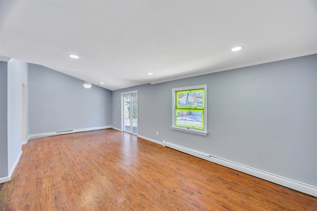 unfurnished room with a baseboard heating unit, hardwood / wood-style flooring, and ornamental molding