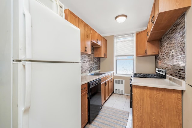 kitchen featuring light tile patterned floors, radiator, dishwasher, tasteful backsplash, and white fridge