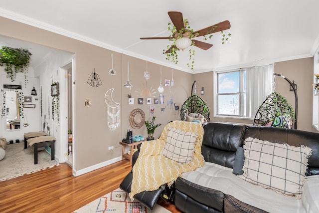 living room featuring hardwood / wood-style flooring, ornamental molding, and ceiling fan