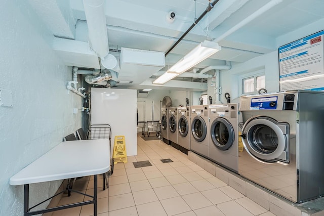 laundry area featuring washer and dryer and light tile patterned floors