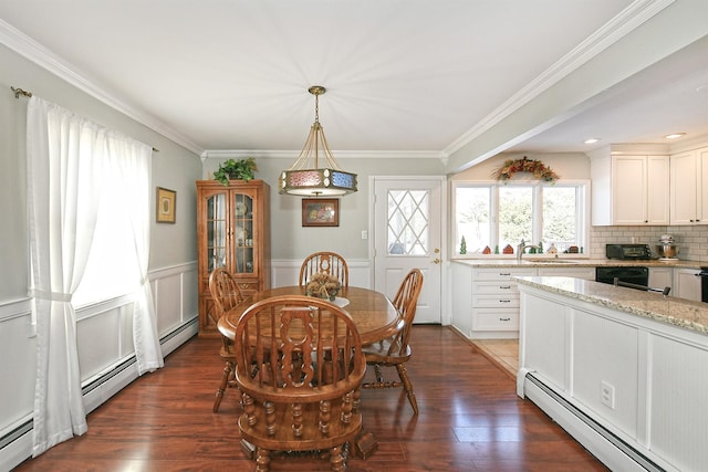 dining room with baseboard heating, dark hardwood / wood-style floors, crown molding, and sink