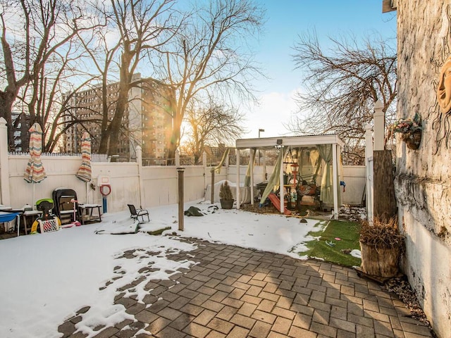 snow covered patio featuring a playground