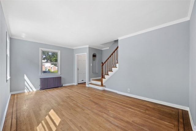 interior space featuring crown molding, radiator heating unit, and light hardwood / wood-style flooring