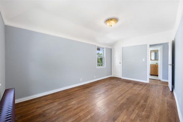 interior space featuring dark wood-type flooring and vaulted ceiling