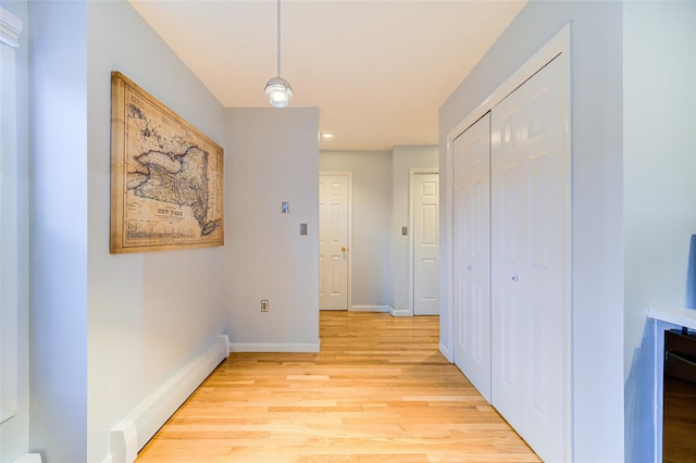 hall featuring a baseboard radiator and light hardwood / wood-style floors