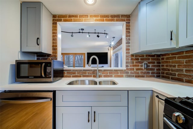 kitchen with stainless steel appliances, sink, and gray cabinetry