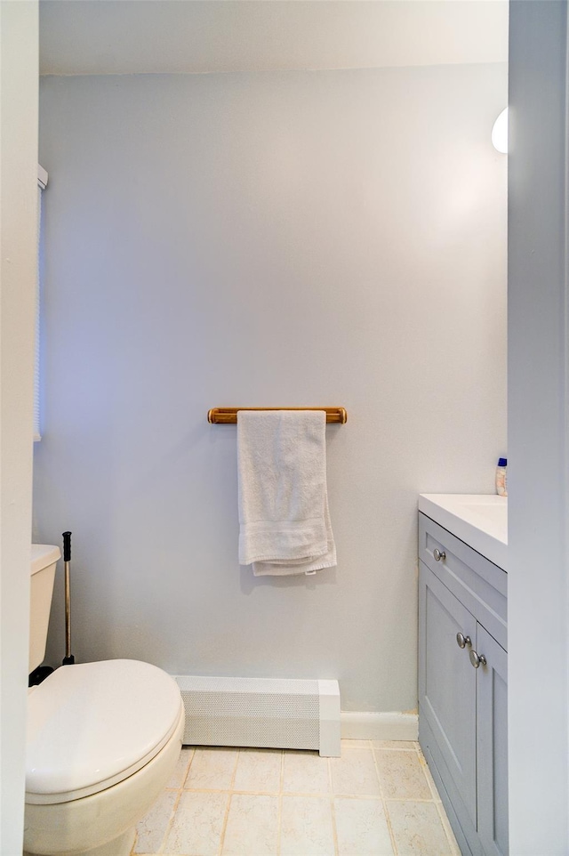 bathroom featuring vanity, baseboard heating, and toilet