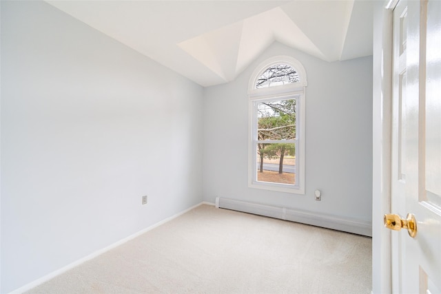 carpeted empty room with a baseboard radiator and vaulted ceiling