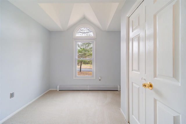 carpeted spare room with lofted ceiling and a baseboard heating unit