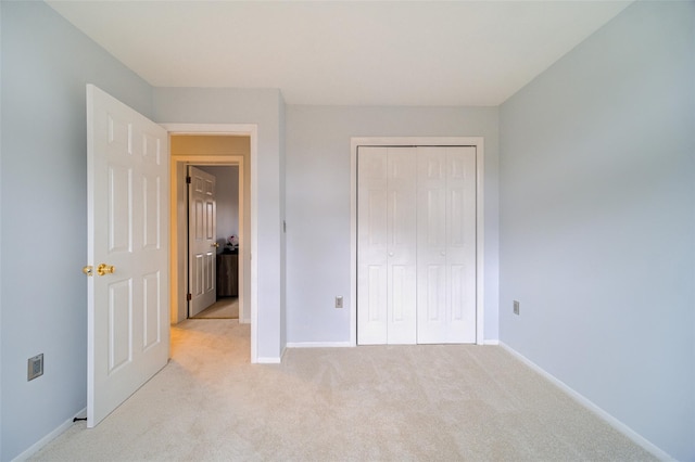 unfurnished bedroom featuring light colored carpet and a closet