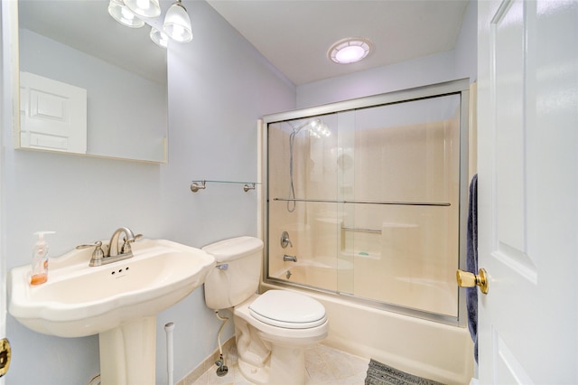 full bathroom featuring sink, bath / shower combo with glass door, tile patterned floors, and toilet