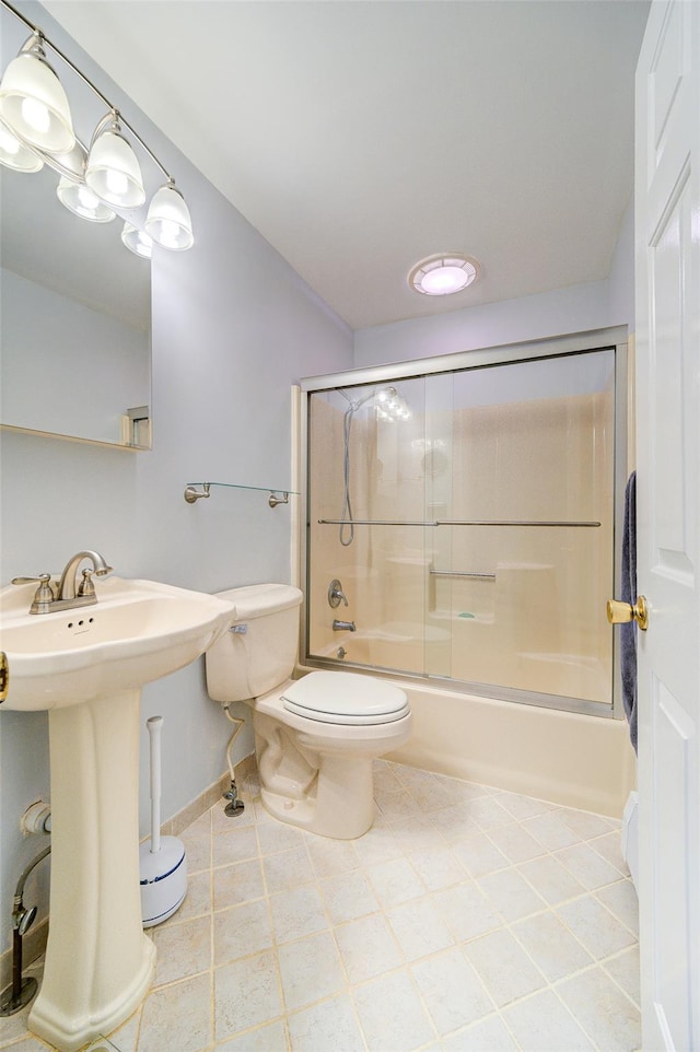 bathroom with tile patterned floors, toilet, and combined bath / shower with glass door