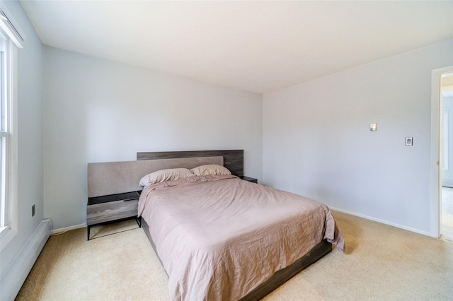 bedroom featuring a baseboard heating unit and light carpet