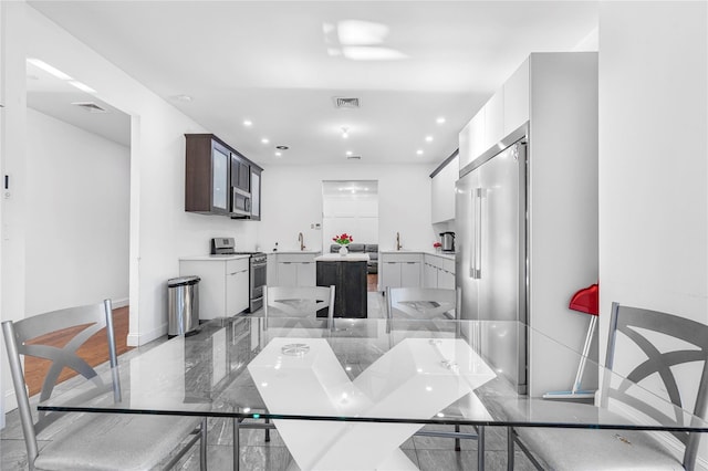 kitchen with appliances with stainless steel finishes, dark brown cabinets, and white cabinets