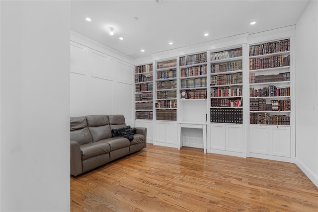 living area featuring built in features and light hardwood / wood-style flooring