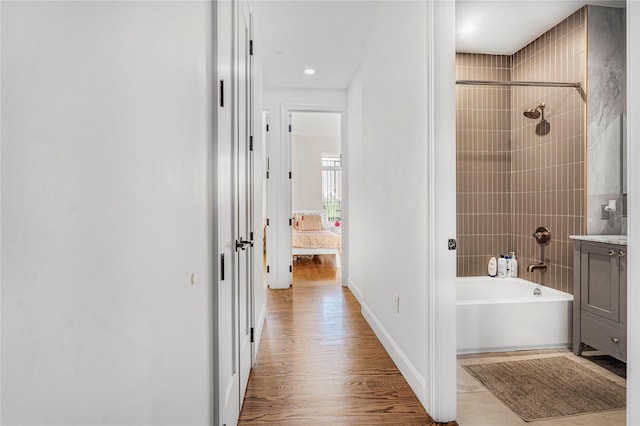 bathroom with hardwood / wood-style floors and tiled shower / bath combo