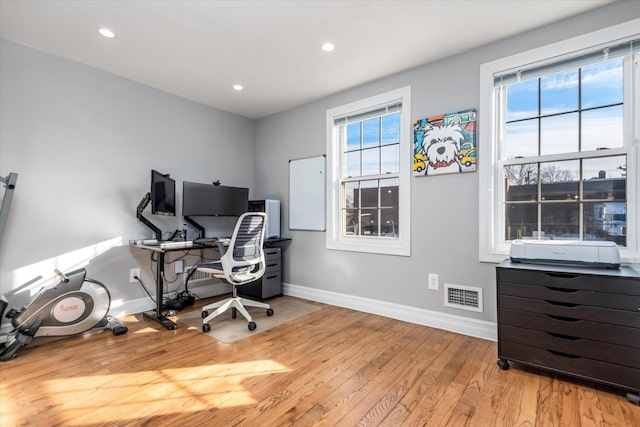 home office with light hardwood / wood-style floors