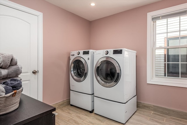 laundry area featuring light hardwood / wood-style floors and washing machine and clothes dryer