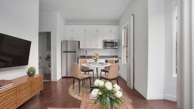 kitchen featuring stainless steel appliances, white cabinets, and dark hardwood / wood-style flooring