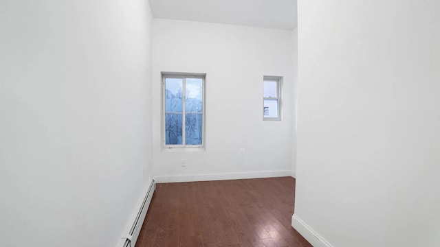 spare room featuring a baseboard radiator and dark hardwood / wood-style floors