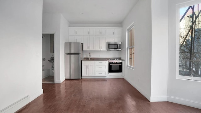 kitchen featuring baseboard heating, appliances with stainless steel finishes, dark hardwood / wood-style floors, and white cabinets